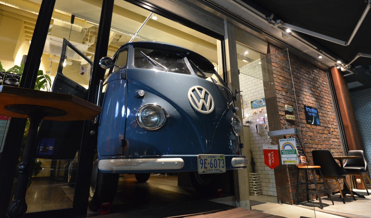 夜、静かになった通りに顔を出すワーゲンバスの向こうで、店の灯りはまだ灯っている